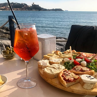 Italian aperitivo with spritz and antipasti by the sea