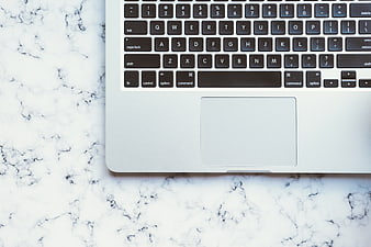 Top View of Silver Laptop on White Marble Surface