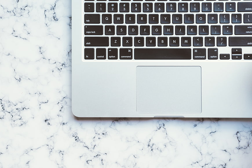 Top View of Silver Laptop on White Marble Surface