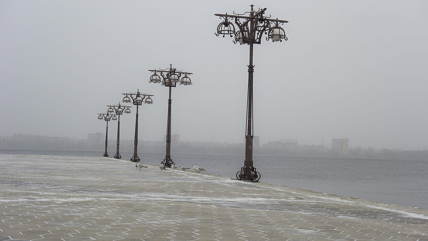 Foggy Winter Promenade with Vintage Street Lamps and Seagulls