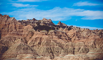 Dramatic Badlands Rock Formations Under Blue Sky