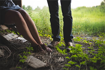 Couple's legs and feet in nature with green grass background