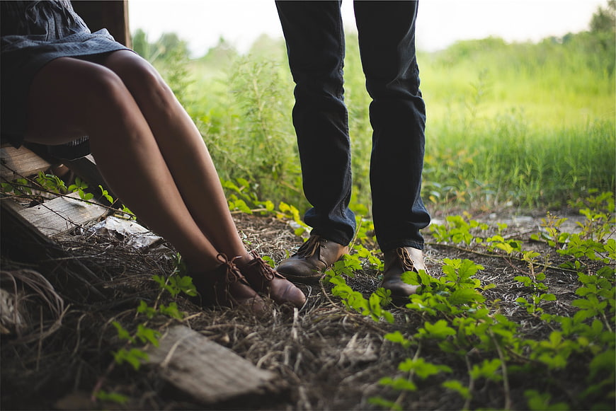 Couple's legs and feet in nature with green grass background