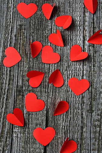 Red Paper Hearts Scattered on Weathered Gray Wooden Planks