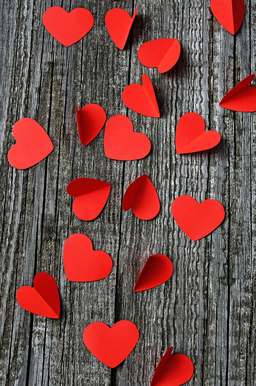 Red Paper Hearts Scattered on Weathered Gray Wooden Planks