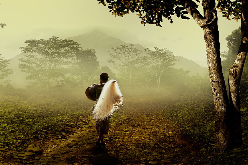 Fisherman walking with net in misty mountain landscape