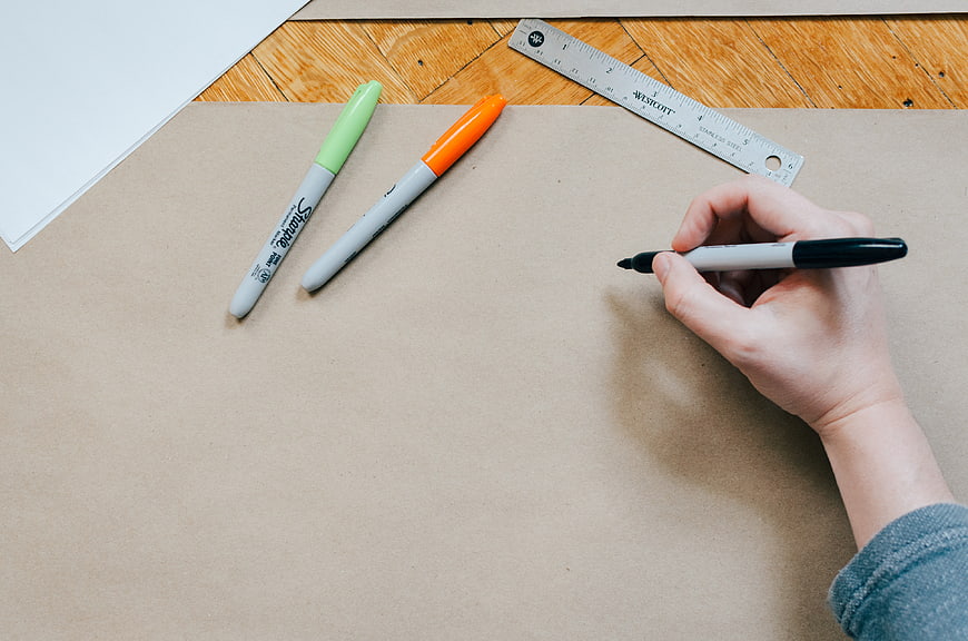 Hand drawing on cardboard with markers and ruler