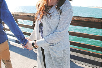 Couple Holding Hands on Pier by the Ocean