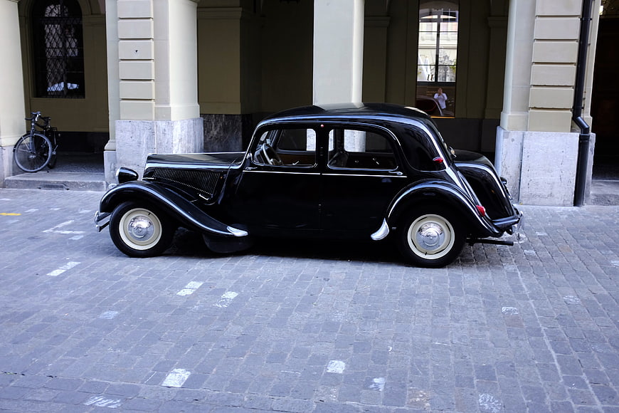 Vintage black classic car parked on cobblestone street