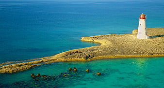 Aerial View of White Lighthouse on Rocky Island Coast