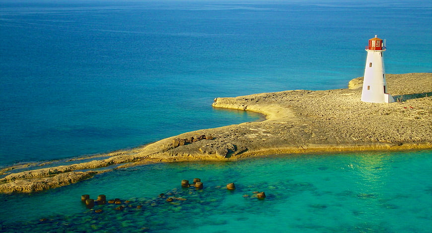 Aerial View of White Lighthouse on Rocky Island Coast