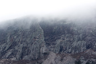 Misty rocky mountain cliff landscape with fog