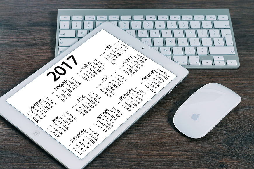 2017 Calendar On Tablet With Apple Keyboard And Mouse On Wood Desk