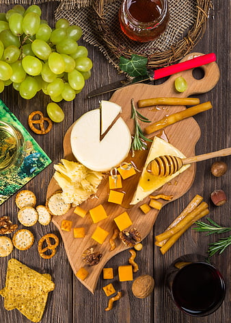 Gourmet cheese board with grapes, crackers, and wine