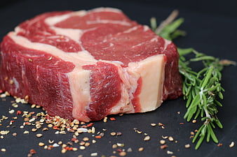 Raw Beef Steak With Rosemary And Spices On Dark Slate