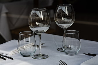 Elegant wine glasses and cutlery on a white tablecloth