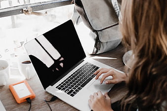 Woman Working on Laptop in Coffee Shop