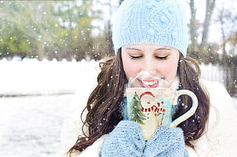 Happy Woman Drinking Hot Cocoa in Snowy Winter