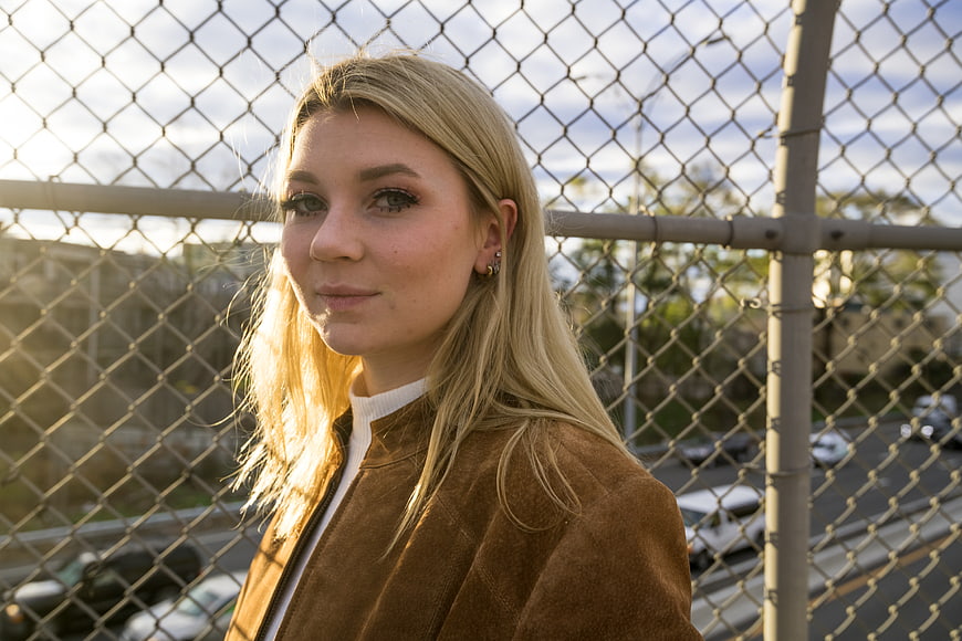 Blonde Woman Portrait in Front of Chain Link Fence