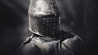 Close-up of medieval knight wearing riveted steel helmet and armor