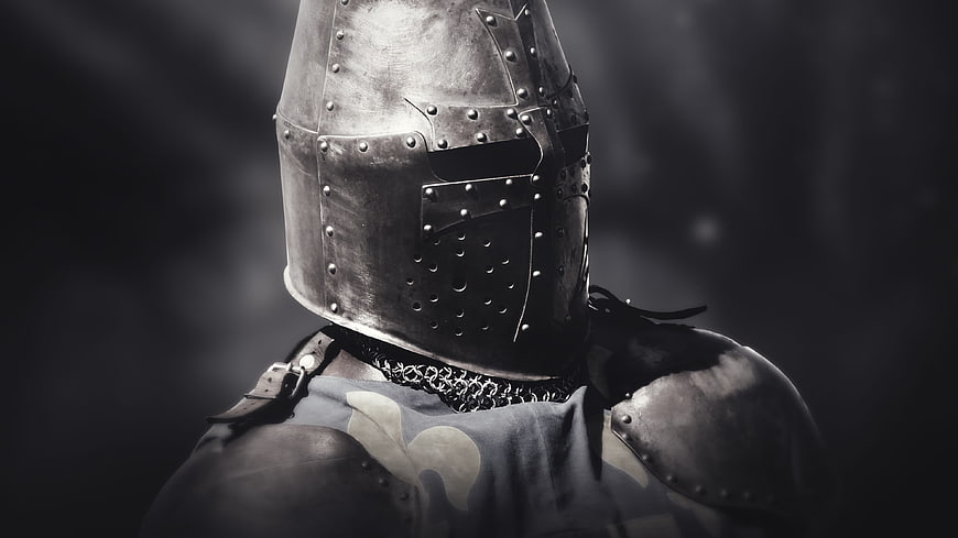 Close-up of medieval knight wearing riveted steel helmet and armor
