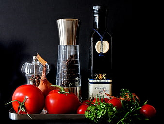 Fresh tomatoes, olive oil, and spices on a dark background