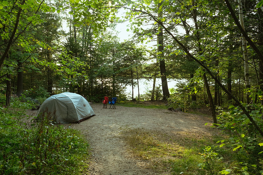 Peaceful Forest Campsite with Tent and Lake View