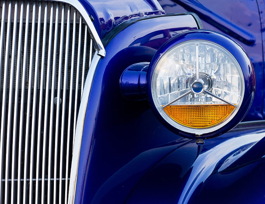 Close-up of Classic Blue Car Headlight and Chrome Grille