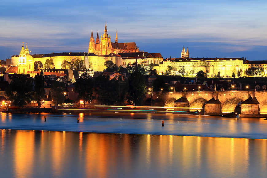 Prague Castle and Charles Bridge illuminated at twilight over Vltava River