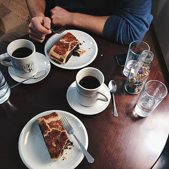Overhead view of coffee and poppy seed strudel on wooden table