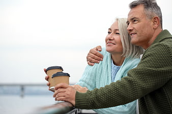 Happy Senior Couple Drinking Coffee on Balcony