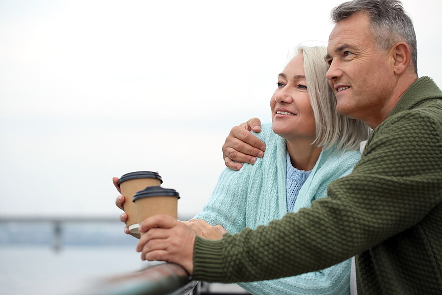 Happy Senior Couple Drinking Coffee on Balcony