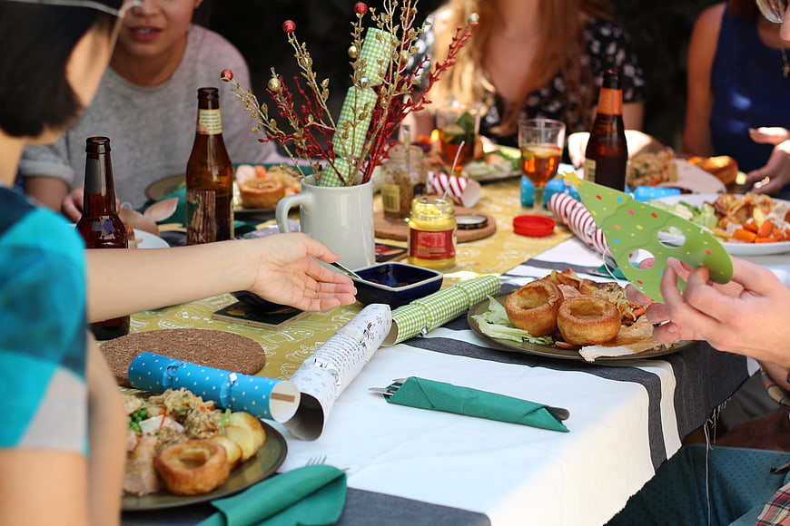 Friends enjoying a festive outdoor meal with food and drinks