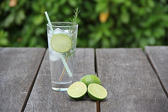 Gin and Tonic Cocktail with Lime and Rosemary on Wooden Table