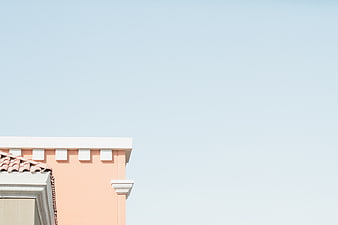 Minimalist pink building corner against clear blue sky