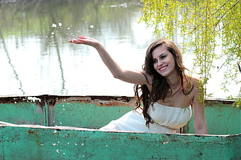 Woman in White Dress Splashing Water in Rusty Boat