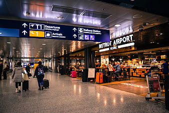 Travelers walking in Helsinki Airport terminal near bistro