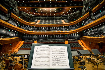 Open sheet music on stand in empty concert hall
