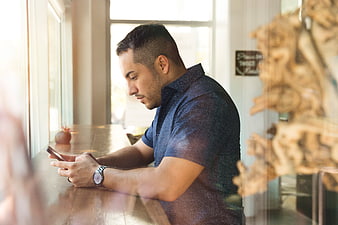 Man using smartphone at cafe window