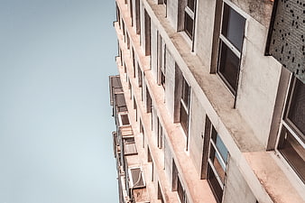 Low angle view of concrete apartment building against blue sky