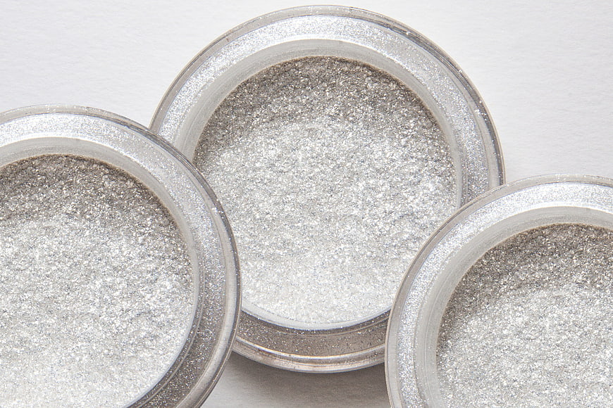 Close-up of silver glitter powder in cosmetic jars