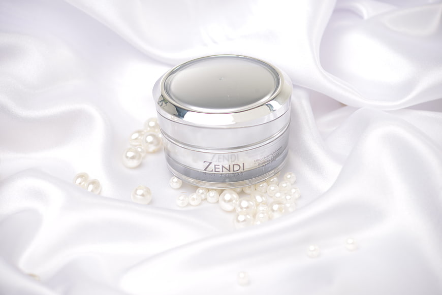 Luxury skincare cream jar on white silk with pearls