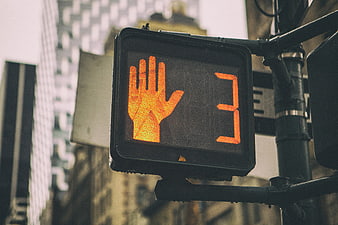 Orange pedestrian crossing signal with countdown timer in urban city street