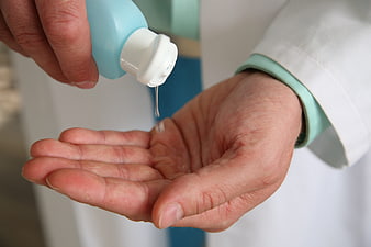 Medical professional dispensing hand sanitizer into open palm