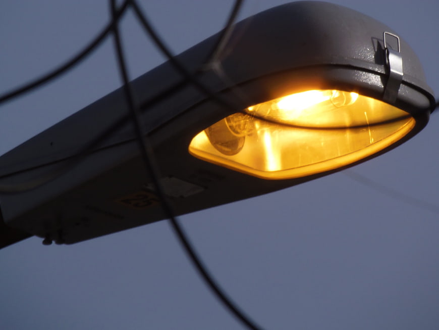Glowing yellow street lamp against blue twilight sky