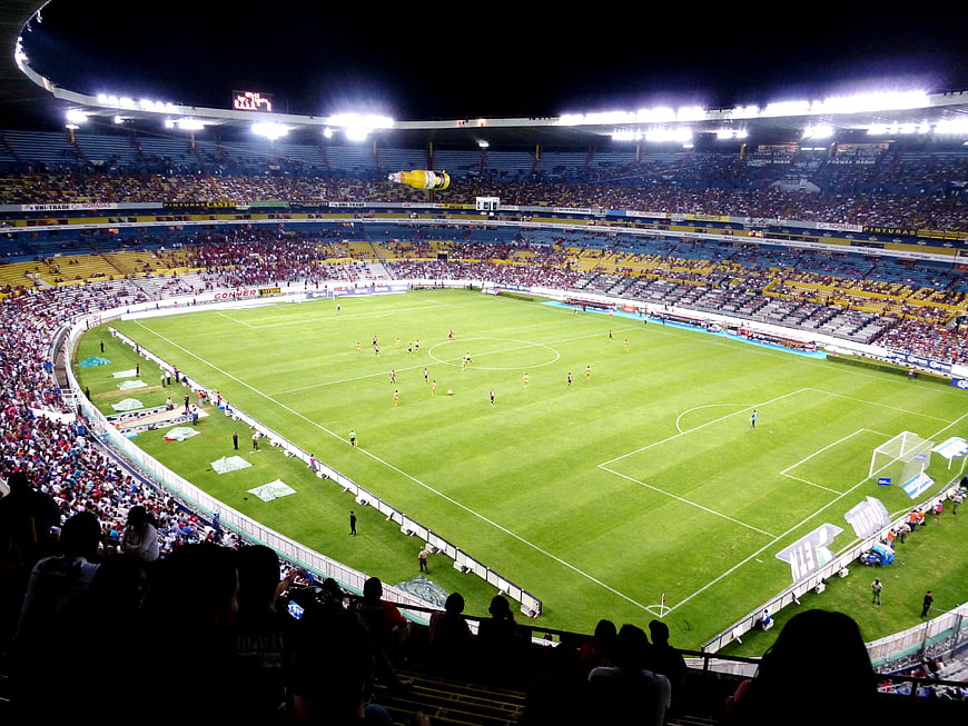 Wide Night View of Soccer Stadium with Crowd and Green Pitch