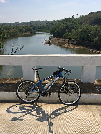 Blue mountain bike on bridge overlooking river