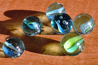 Vintage glass marbles on wooden surface