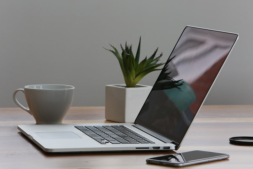 Modern workspace with laptop, coffee cup, and succulent plant