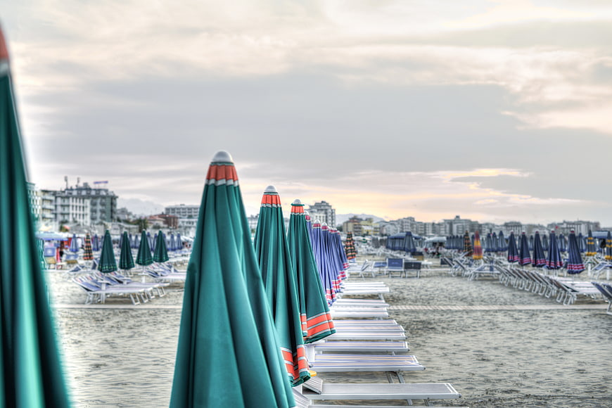 Empty Beach with Closed Green Umbrellas at Sunset